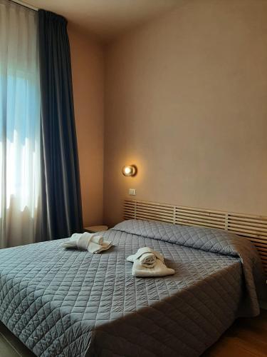 a bedroom with a bed with towels on it at Hotel Alabama by ALEhotels in Rimini