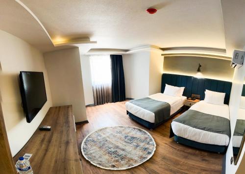 a hotel room with two beds and a flat screen tv at Nira Boutique Hotel in Ankara