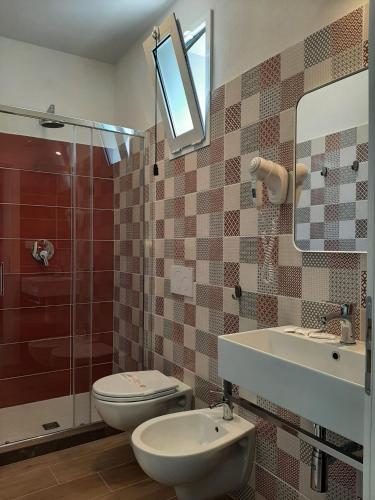 a bathroom with a toilet and a sink and a shower at Hotel Alabama by ALEhotels in Rimini