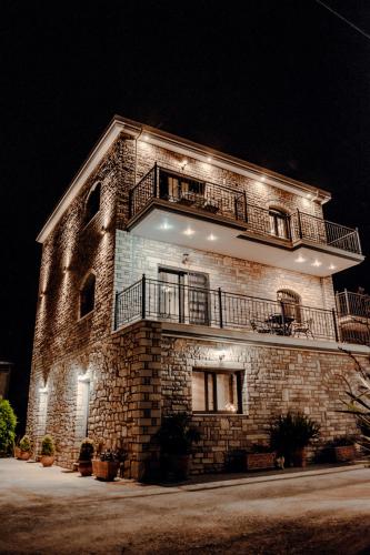 a large brick building with lights on it at night at To Petrino (VIlla Markos) in Parga