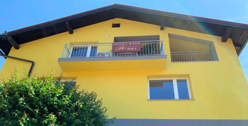 a yellow building with a balcony and a sign on it at Apartmaji Prʼ nas in Laško