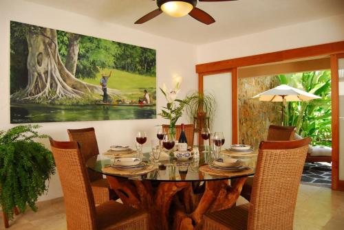 Un comedor con una mesa con copas de vino. en Feliz Villa 4, en Ixtapa