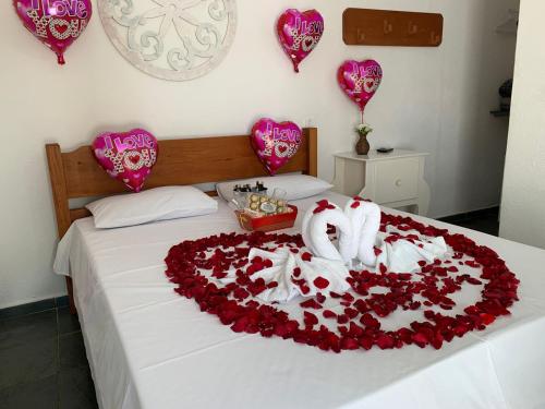 uma cama com um coração feito de rosas vermelhas em Pousada Cachoeira em Serra Negra