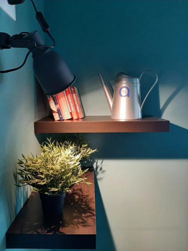 a shelf with a lamp and a potted plant on it at Hotel Alabama by ALEhotels in Rimini