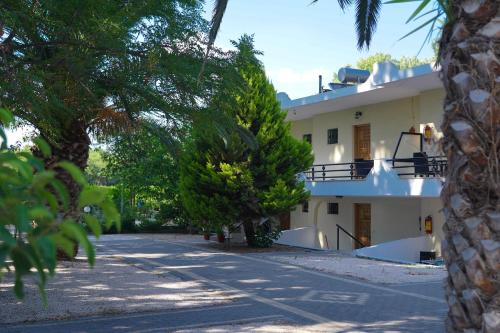a white building with trees in front of it at Beach Side Apartments in Dhrepanon
