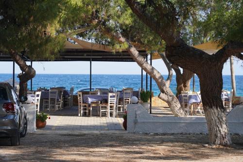 a patio with chairs and tables on the beach at Beach Side Apartments in Dhrepanon