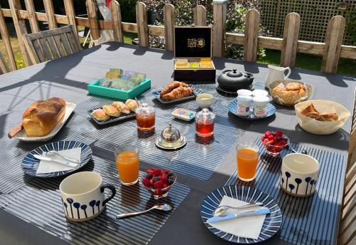 a table with breakfast foods and drinks on it at ENTRE TERRE ET MER in Blonville-sur-Mer