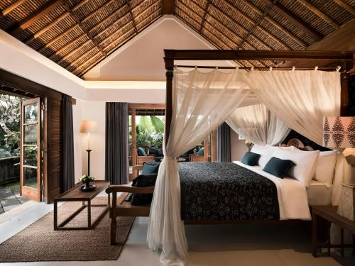 a bedroom with a bed with a canopy at Kharista Villas & Retreat by Ekosistem in Canggu