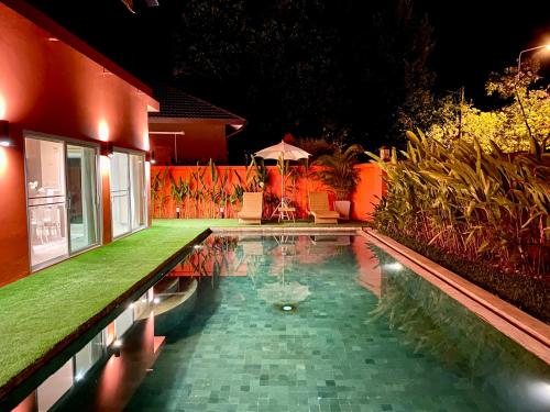 Ban Huai SieoにあるHugo Villa (3-Bedroom Pool villa + Rooftop)の夜の家の前のプール