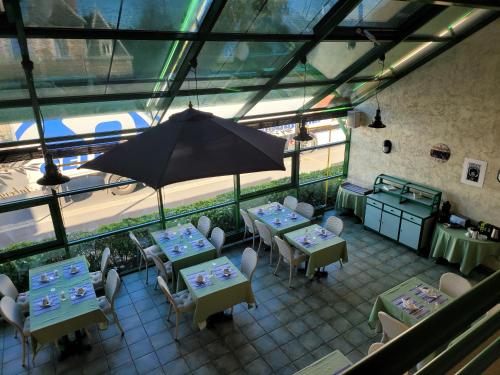 an overhead view of a restaurant with tables and an umbrella at L'AUBERGE DE L'OLIVE in Dompierre-sur-Besbre