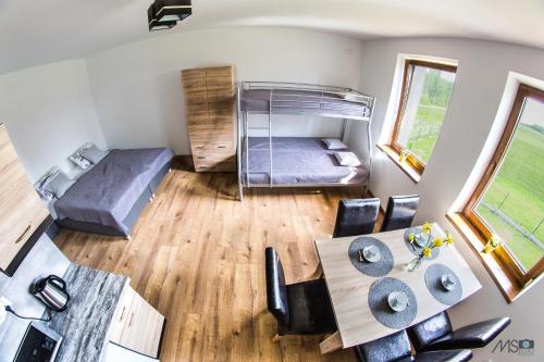 a small room with a bed and a table and chairs at Apartamenty Tilia Laskowa - Zator in Laskowa