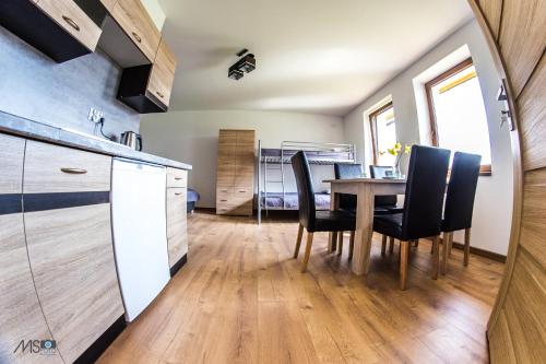 a kitchen and dining room with a table and chairs at Apartamenty Tilia Laskowa - Zator in Laskowa