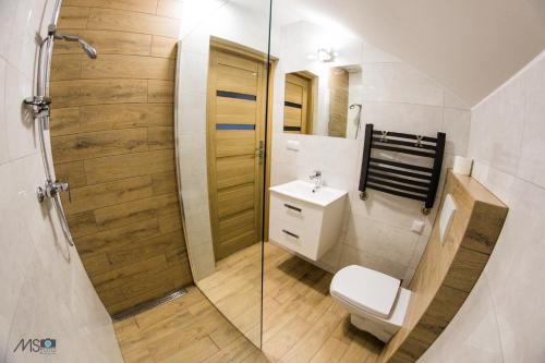 a bathroom with a toilet and a sink and a shower at Apartamenty Tilia Laskowa - Zator in Laskowa