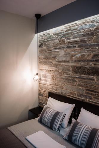 a bedroom with a brick wall behind a bed at To Petrino (VIlla Markos) in Parga