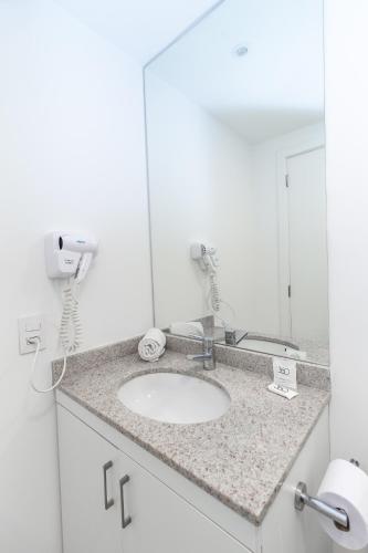 a bathroom with a sink and a mirror at 360 Suítes Sé in Sao Paulo