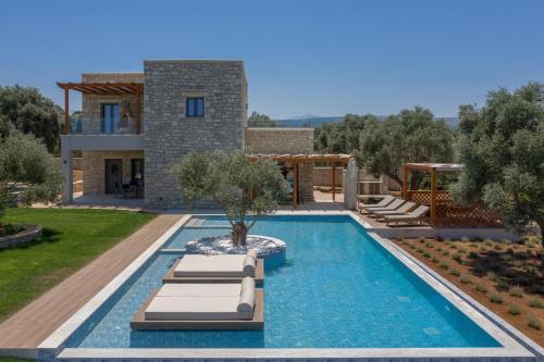 a villa with a swimming pool and a house at Thyme Villa in Prínos