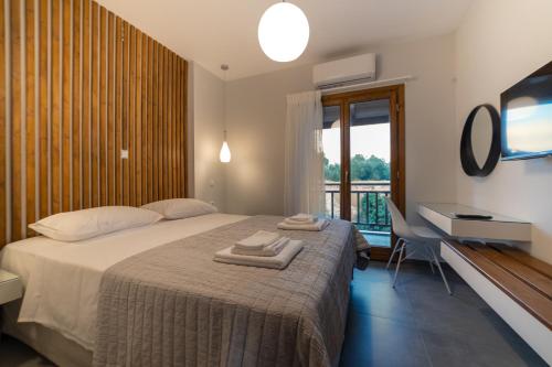 a bedroom with a bed and a desk and a television at IONIS Apartments in Preveza