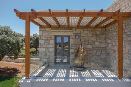 a patio with a wooden pergola at Thyme Villa in Prínos