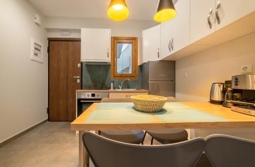 a kitchen with a wooden table and chairs at IONIS Apartments in Preveza