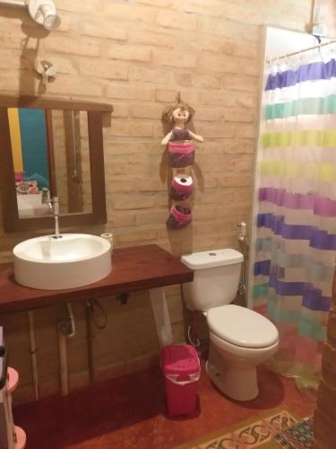 a bathroom with a sink and a toilet and a mirror at Casa do deck - Serra - Santo Antonio do Pinhal in Santo Antônio do Pinhal
