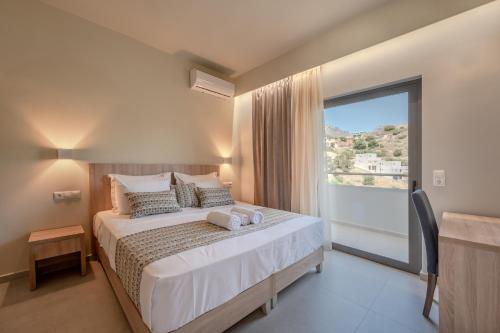 a bedroom with a large bed with a large window at Sunset View in Plakias