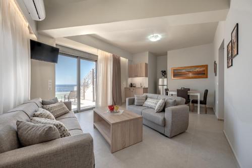 a living room with two couches and a table at Sunset View in Plakias