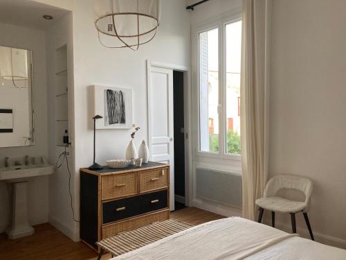 - une chambre avec un lit, un lavabo et une fenêtre dans l'établissement la boutique mj décoration vous propose de découvrir ses deux chambres d'hôtes, à Doué-la-Fontaine