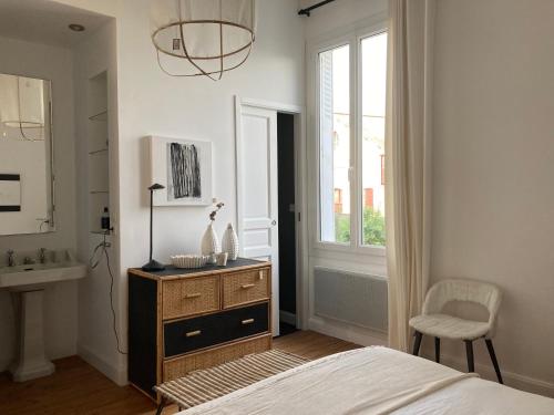 a bedroom with a bed and a sink and a window at la boutique mj décoration vous propose de découvrir ses deux chambres d'hôtes in Doué-la-Fontaine