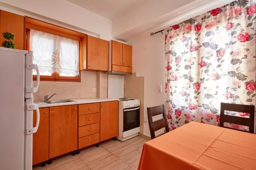 a kitchen with wooden cabinets and a stove top oven at Niotis Studios in Diafani