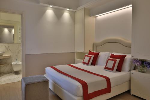 a bedroom with a large bed with red and white pillows at Hotel Tigullio Et De Milan in Santa Margherita Ligure