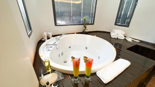 a bathroom with a large bath tub with two cocktails at Nira Boutique Hotel in Ankara