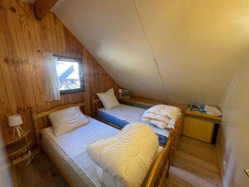 two beds in a small room with a window at Chalet Barcelonnette, 4 pièces, 8 personnes - FR-1-165A-121 in Barcelonnette