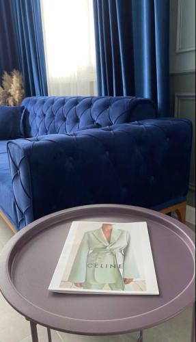 a living room with a blue couch and a table at Express Inn in Poti