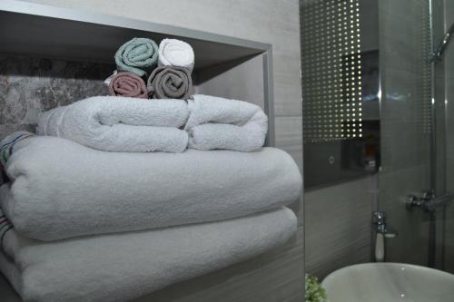 a bunch of towels are stacked in a bathroom at Dune, apartament magic la marginea orasului in Floreşti