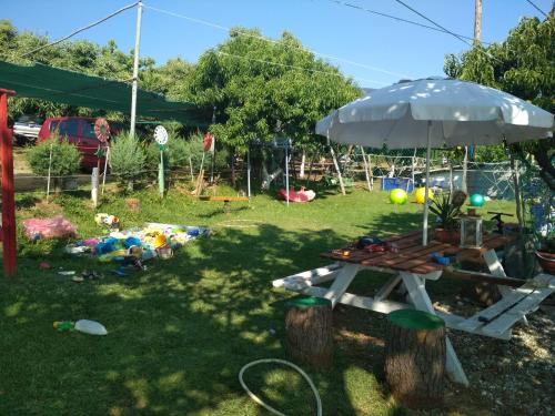 a picnic table and an umbrella in a yard at Kastra in Velika