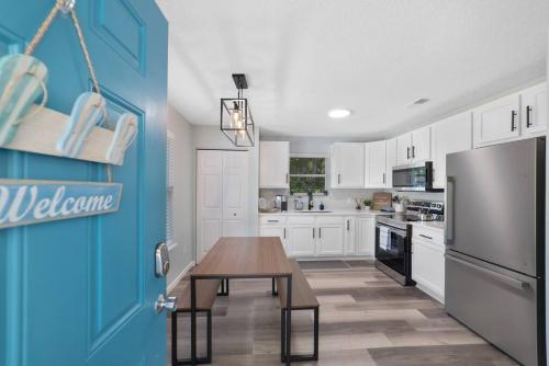 a kitchen with a wooden table and a refrigerator at NEW Modern Bungalow Close to Downtown! Fully Fenced Yard in Saint Augustine