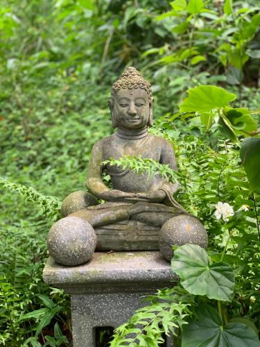 a statue sitting on top of a stone bench at mon Ecolodge Creole in Fort-de-France