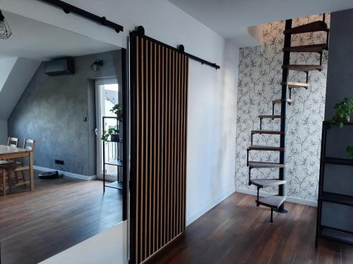 a room with a wooden door and a spiral staircase at Uroczy apartament z dostępnym parkingiem i ogrodem in Szczytniki