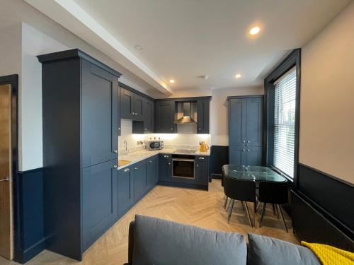 a kitchen with blue cabinets and a table in it at Roe Valley Apartments in Limavady
