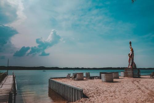 a statue on a beach next to a body of water at Dom Wypoczynkowy "Pod Strzechą" w Giewartowie in Giewartów