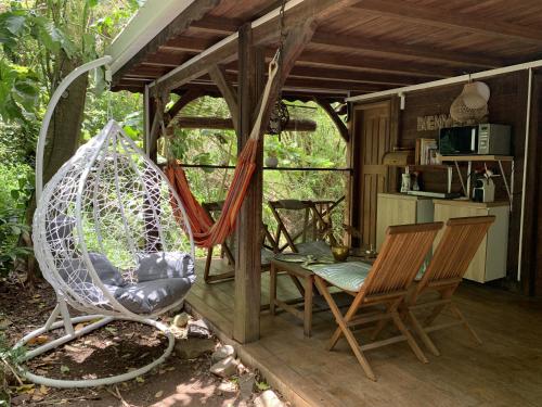 eine Veranda mit 2 Stühlen und einer Schaukel in der Unterkunft mon Ecolodge Creole in Fort-de-France