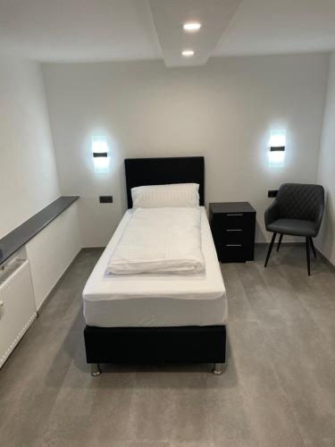 a bedroom with a bed and a chair in it at Hotel Anker in Großenlinden