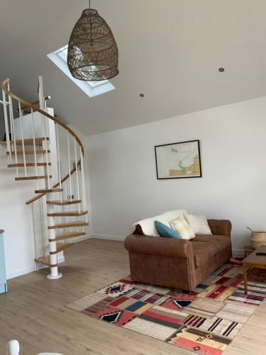 a living room with a couch and a spiral staircase at The Birdhouse with Hot Tub in Gortahork