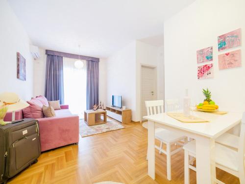 a living room with a pink couch and a table at Peace 2 Apartments with parking in Budva