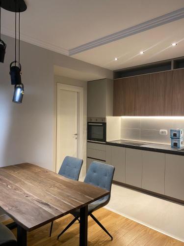 a kitchen with a wooden table and blue chairs at Apartman VT Central point in Podgorica