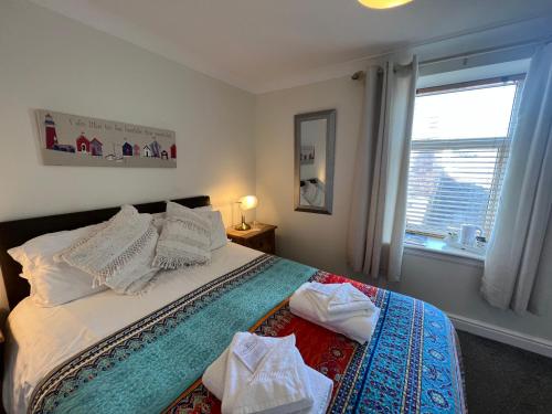 a bedroom with a large bed with a window at Anchor Hotel in Johnshaven