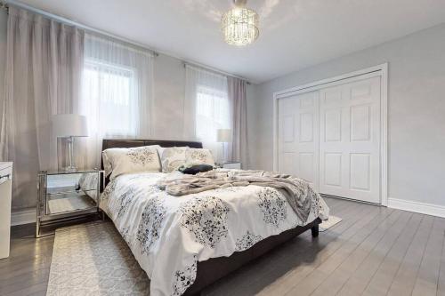 a bedroom with a bed and a chandelier at Cozy 3 bedroom townhouse near Canada's Wonderland! in Vaughan