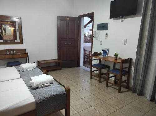 a hotel room with two beds and a table and a table at Vythos in Adamas