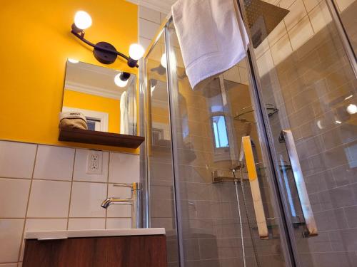 a bathroom with a shower with a glass door at Motel Abricafé in Stoneham