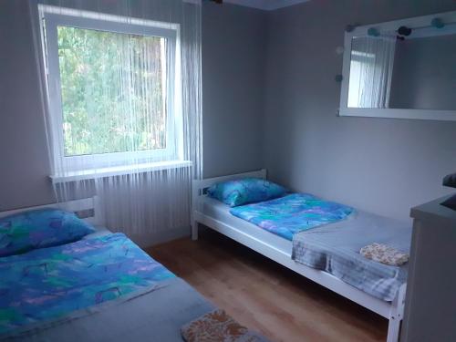 sypialnia z dwoma łóżkami i oknem w obiekcie Sleeping Harsz w mieście Harsz